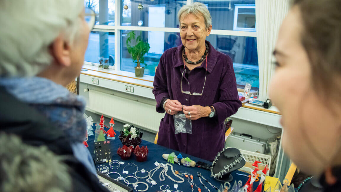 Besøgende kigger på bod med smykker og glaskunst