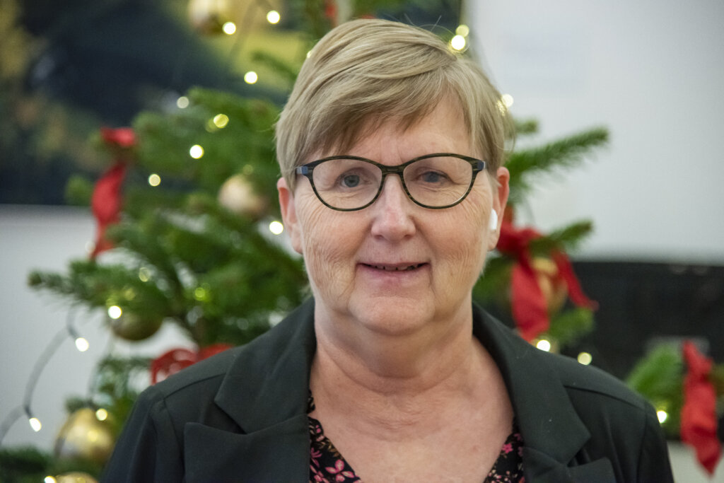 Portræt af smilende Gitte foran flot pyntet juletræ