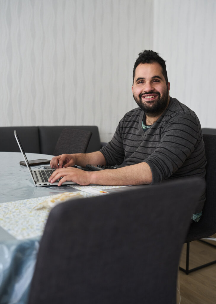 Mohammed kigger op fra sin computer og smiler