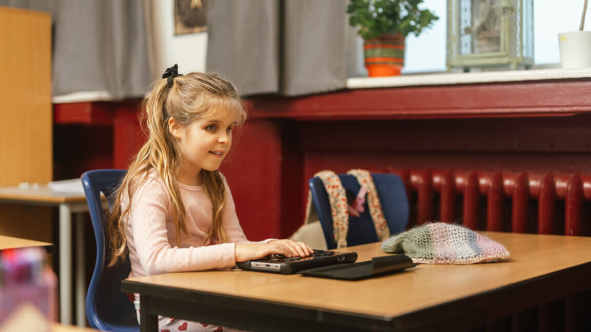 9-årige Paloma skriver på sit notatapparat i klaseværelset