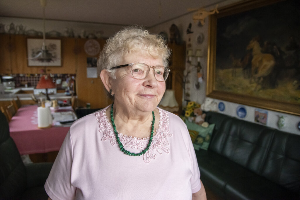 Brita st&aring;r smilende i sin stue, 