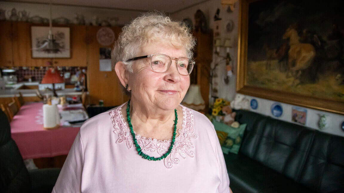 Brita står smilende i sin stue,