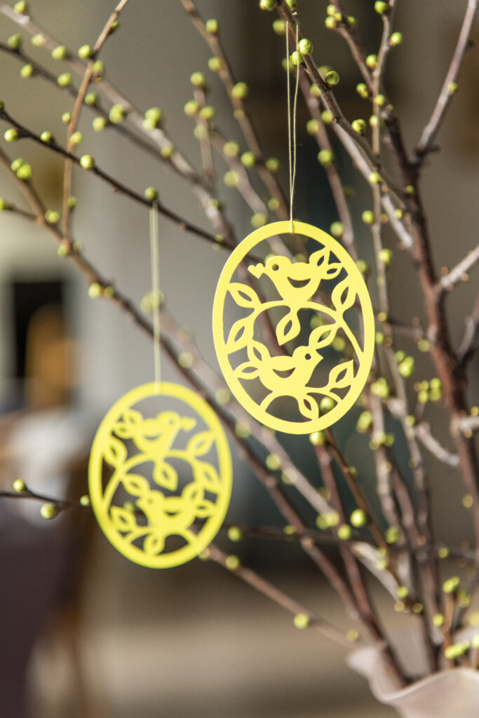 P&aring;skepynten h&aelig;nger p&aring; for&aring;rsgrene. Pynten har form som et &aelig;g, hvori, der er udstukket to fugle, der sidder p&aring; hver deres gren med et hjerte i n&aelig;bbet