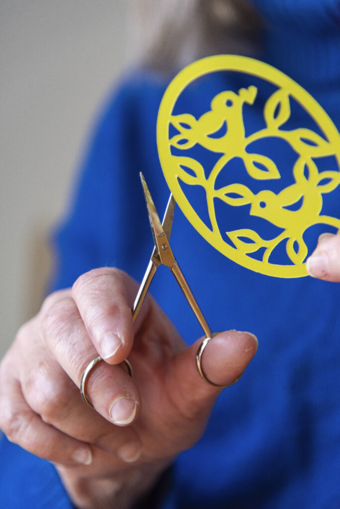 N&aelig;rbillede af Gittes h&aring;nd, som klipper p&aring;skepynten