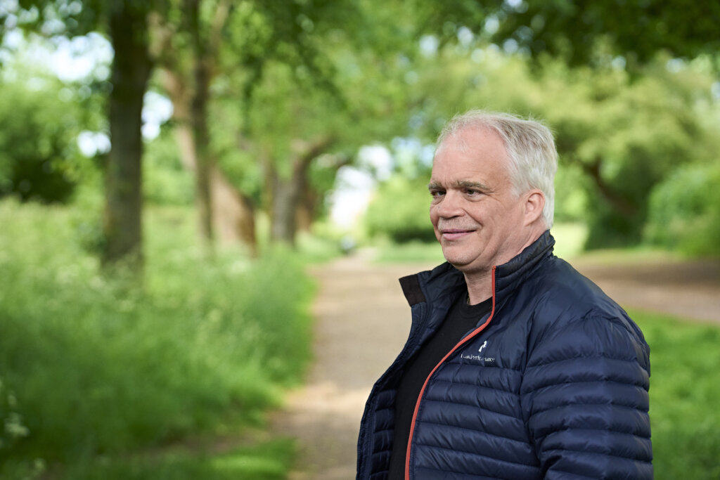 Portr&aelig;t af smilende Poul, der st&aring;r i en park