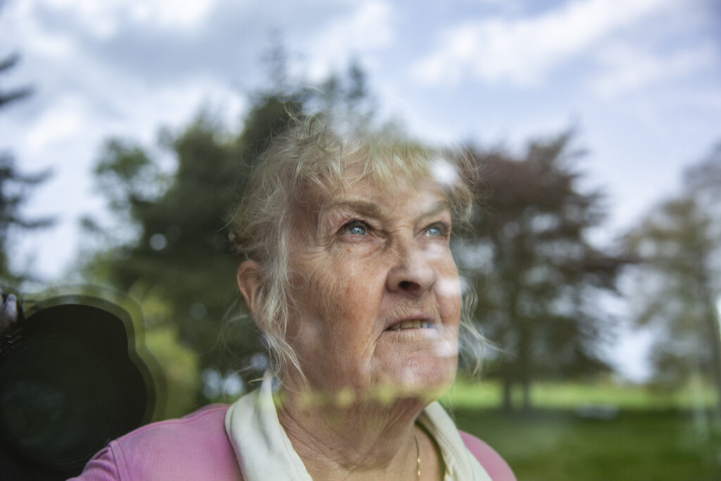 Susanne kigger gennem et vindue, hvor omgivelserne reflekteres