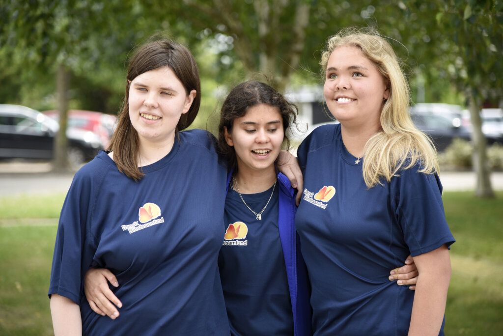 Sarah st&aring;r med to veninder, der har ens t-shirts p&aring; fra Sommerskolen