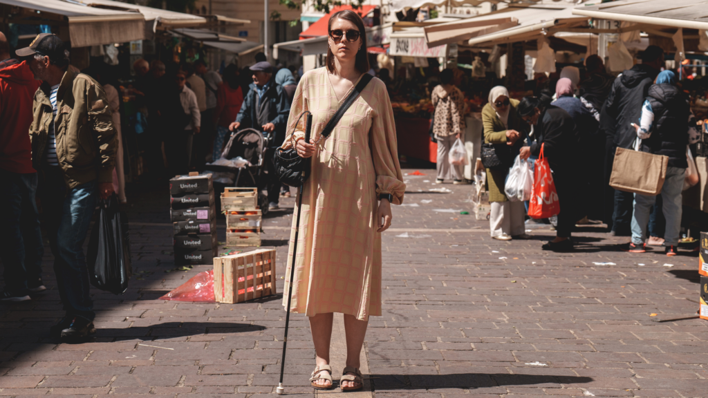 C&aelig;cilie st&aring;r med sin blindestok p&aring; et madmarked i Marseille
