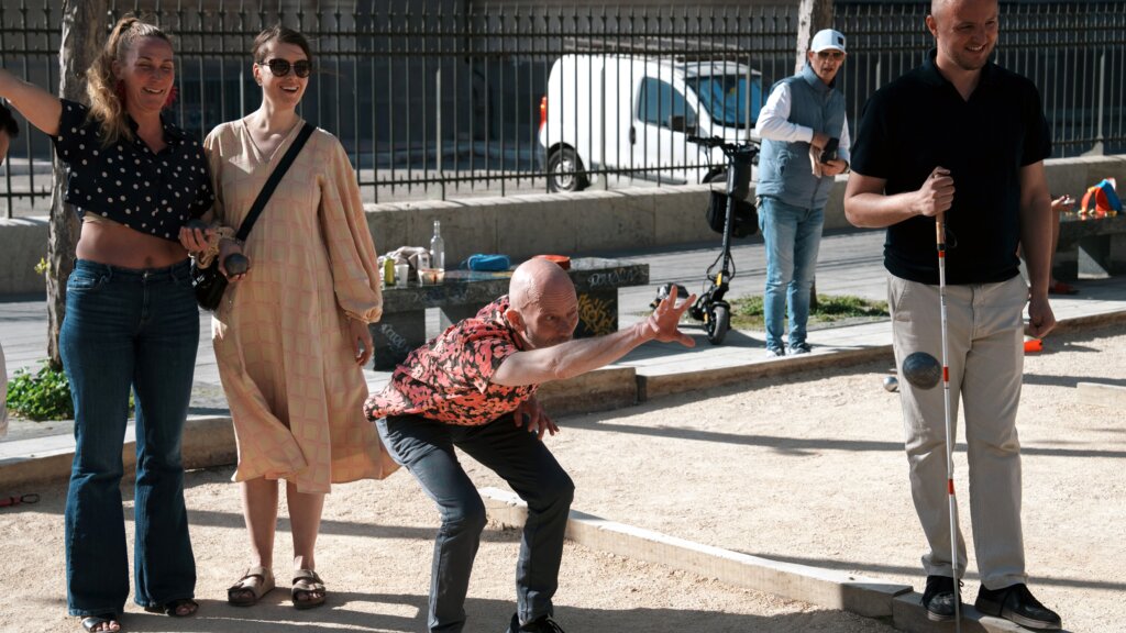 Frank kaster bolden i petanque. Ved siden af står Edis, Cæcilie og Christina
