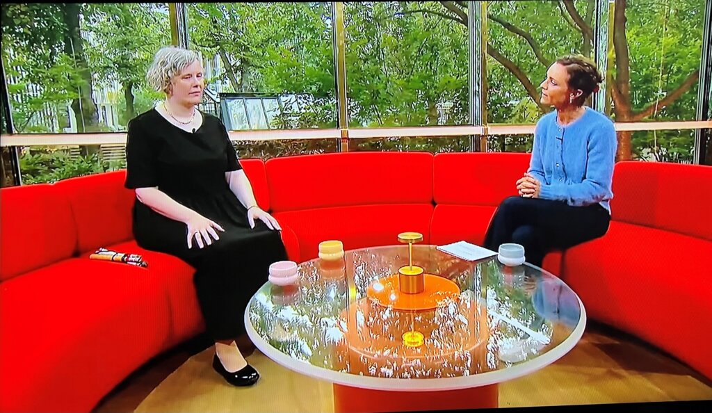 Anne Sofie sidder sammen med v&aelig;rten i den r&oslash;de sofa i Go' morgen Danmarks studie