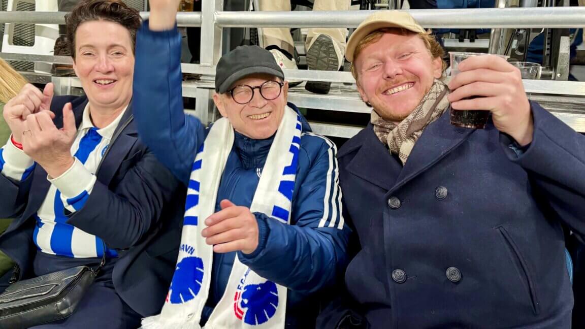 Mariann, Børge og Kristian har FCK tørklæder på og hepper på tribunen